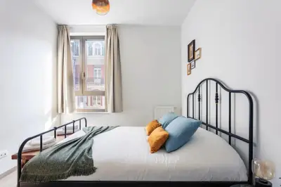 a bedroom with a bed with blue and orange pillows at Sunny haven in Antwerp
