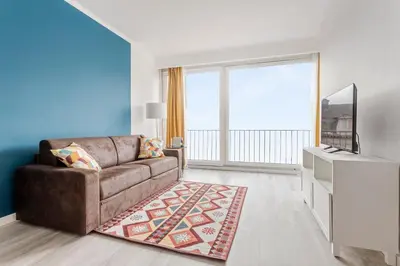 a living room with a brown couch and a large window at Center of Antwerp, Fully Equipped, Train Station in Antwerp
