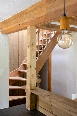 a wooden staircase in a house with a ceiling at 't Jongehof in Zaffelare