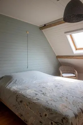 a bedroom with a bed in a attic with a window at 't Jongehof in Zaffelare