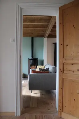a living room with a couch and a wooden door at 't Jongehof in Zaffelare