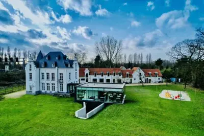 a large white house on a grassy field at Kasteel Boterlaerhof Antwerpen in Antwerp