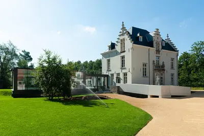 a large house with a water fountain in the yard at Kasteel Boterlaerhof Antwerpen in Antwerp
