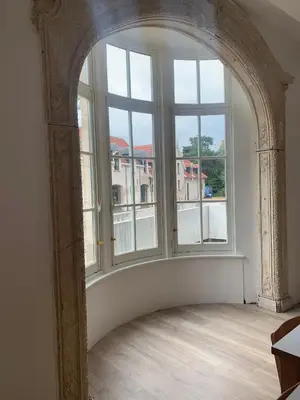 an archway in a room with a large window at Kasteel Boterlaerhof Antwerpen in Antwerp