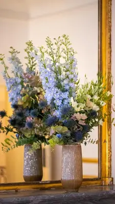 two vases with flowers in front of a mirror at Hotel de Maître de Vaughan in Brussels