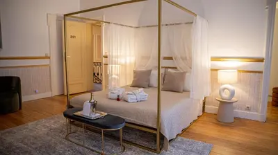 a bedroom with a canopy bed with a mirror at Hotel de Maître de Vaughan in Brussels