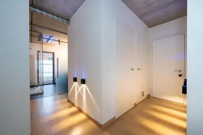 an empty room with white walls and wooden floors at London 993 Loft 402 in Antwerp