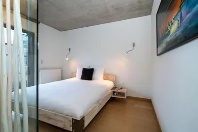 a bedroom with a bed and a glass wall at London 993 Loft 402 in Antwerp
