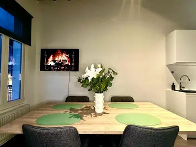 a dining room table with green plates and a vase with flowers at Luxury Suites Princess by Rikas Hotels in Antwerp