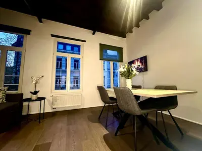 a dining room with a table and chairs and windows at Luxury Suites Princess by Rikas Hotels in Antwerp