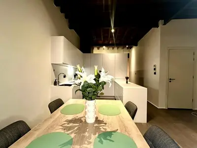 a dining room table with a vase of flowers on it at Luxury Suites Princess by Rikas Hotels in Antwerp