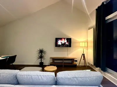 a living room with a couch and a tv on the wall at Luxury Suites Princess by Rikas Hotels in Antwerp