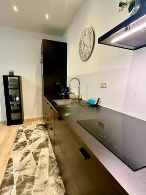 a kitchen with a sink and a clock on the wall at Luxury Suites Centrum by Rikas Hotels in Antwerp