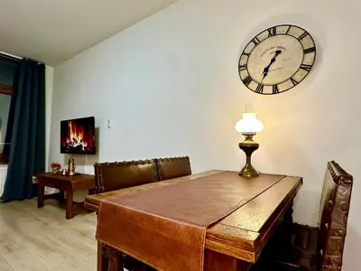 a dining room with a table and a clock on the wall at Luxury Suites Centrum by Rikas Hotels in Antwerp