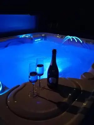 two glasses of wine sitting next to a swimming pool at Vakantievilla met jacuzzi Limburg in Kwaadmechelen