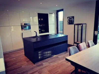a kitchen with a sink and a counter with a table at Vakantievilla met jacuzzi Limburg in Kwaadmechelen