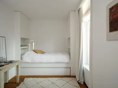 a white bedroom with a bed and a window at CE RESIDENCE in Ghent