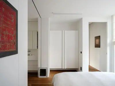 a bedroom with white walls and a white bed at CE RESIDENCE in Ghent