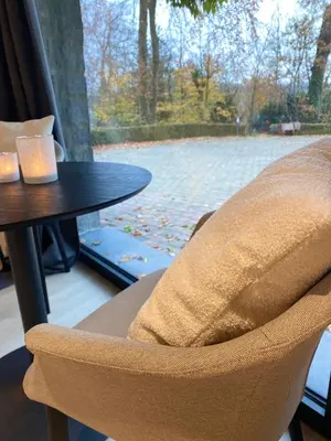 a chair sitting next to a table with a window at Chambres d'hôtes Eucalyptus et Glycine in Genval