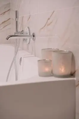 a bathroom with a sink and candles on a shelf at Chambres d'hôtes Eucalyptus et Glycine in Genval
