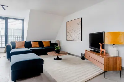 a living room with a couch and a tv at Waterloo Design Residence in Waterloo