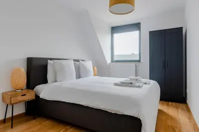 a bedroom with a bed with white sheets and a window at Waterloo Design Residence in Waterloo