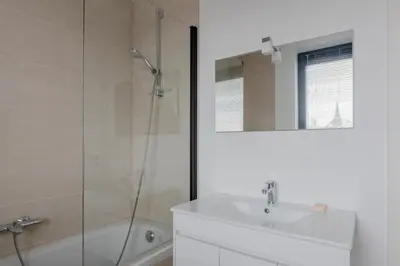 a white bathroom with a sink and a shower at Waterloo Design Residence in Waterloo
