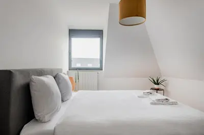 a bedroom with a bed with white sheets and a window at Waterloo Design Residence in Waterloo