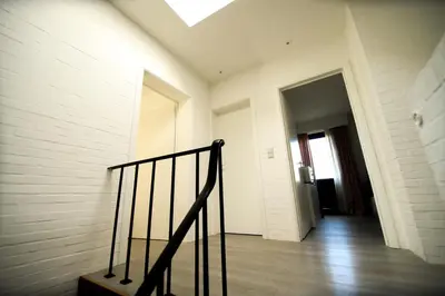 a hallway with a staircase in a white room at Privé kamer met gedeelde badkamer - rand Antwerpen - afrit E313 Wommelgem in Antwerp
