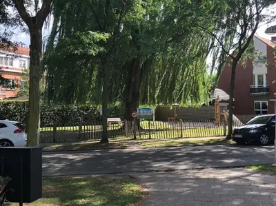 two cars parked next to a fence with trees at Privé kamer met gedeelde badkamer - rand Antwerpen - afrit E313 Wommelgem in Antwerp