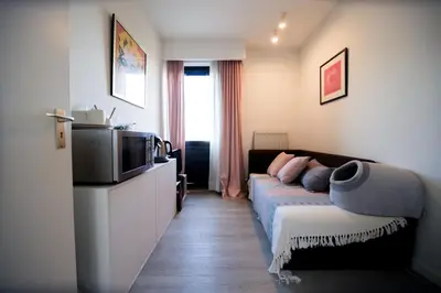 a living room with a couch and a tv at Privé kamer met gedeelde badkamer - rand Antwerpen - afrit E313 Wommelgem in Antwerp