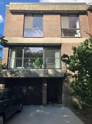 a building with a garage with a car parked in front at Privé kamer met gedeelde badkamer - rand Antwerpen - afrit E313 Wommelgem in Antwerp