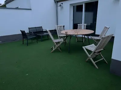 a group of chairs and a table on a patio at Les Cerises, charmante maison au calme in Wavre