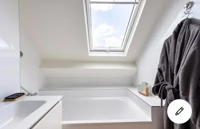 a bathroom with a bath tub and a window at Les Cerises, charmante maison au calme in Wavre