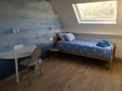 a small room with a bed and a table at Les Cerises, charmante maison au calme in Wavre
