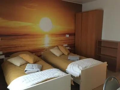 two beds in a room with a painting on the wall at Les Cerises, charmante maison au calme in Wavre