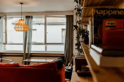 a living room with a couch and a large window at Cosy Apartment with Big Quiet & Sunny terras in Ghent