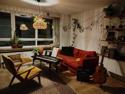 a living room with a red couch and a guitar at Cosy Apartment with Big Quiet & Sunny terras in Ghent