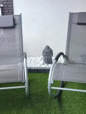 a statue of a head on a bed next to a chair at BRUSSELS EXPO APARTMENT in Brussels