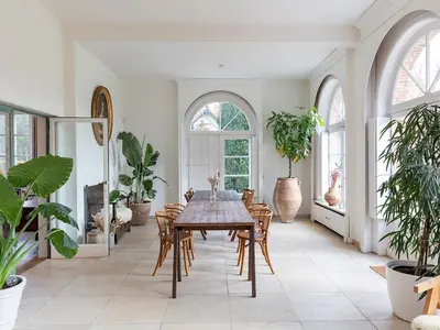 a dining room with a table and some plants at Bleyckhof in een uniek natuurgebied in Ranst