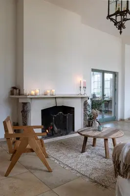 a living room with a fireplace and a wooden table at Bleyckhof in een uniek natuurgebied in Ranst