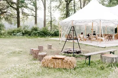 a tent with a picnic table and benches and a grill at Bleyckhof in een uniek natuurgebied in Ranst