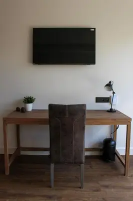 a wooden desk with a chair and a television on a wall at De Kasteelhoeve in Westmalle