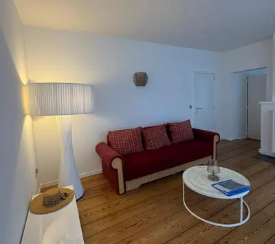 a living room with a red couch and a table at B&B Art and Sleep in Antwerp