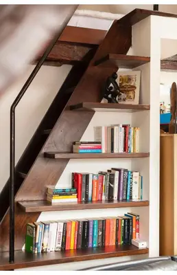 a book shelf filled with books underneath a staircase at B&B Art and Sleep in Antwerp