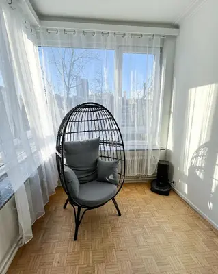 a chair in a room with a large window at Cosy two bedroom apartment in Brussels in Brussels