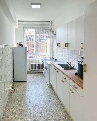 a white kitchen with a sink and a refrigerator at Cosy two bedroom apartment in Brussels in Brussels