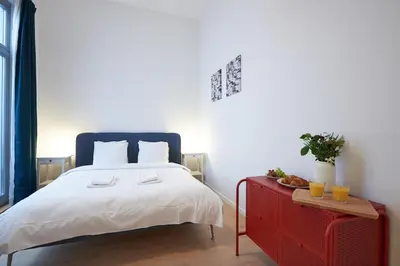 a bedroom with a bed and a red dresser at South Cosy Residence in Brussels