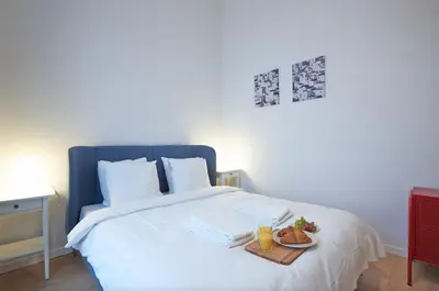 a white bed with a tray of food on it at South Cosy Residence in Brussels