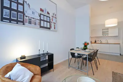 a kitchen and dining room with a table and chairs at South Cosy Residence in Brussels